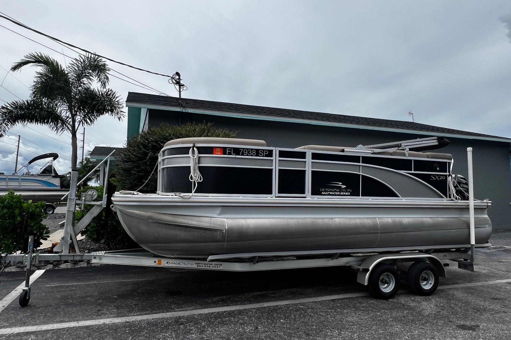 Bennington SX 20 2019 Bennington SX 20 pontoon boat on trailer, parked near palm trees.