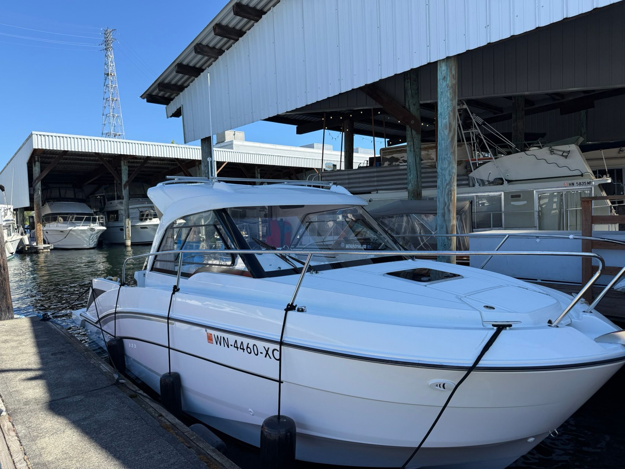 Beneteau Antares 7 2023 Beneteau Antares 7 docked at marina under covered shelter.