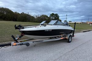 Stingray 192 DC 2023 Stingray C 192 boat on trailer, parked on roadside under cloudy sky.