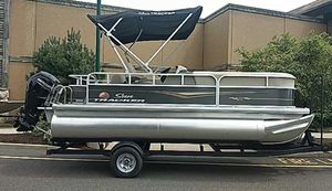 Sun Tracker Party Barge 18 DLX 2025 Sun Tracker Party Barge 18 DLX pontoon boat on trailer, side view.