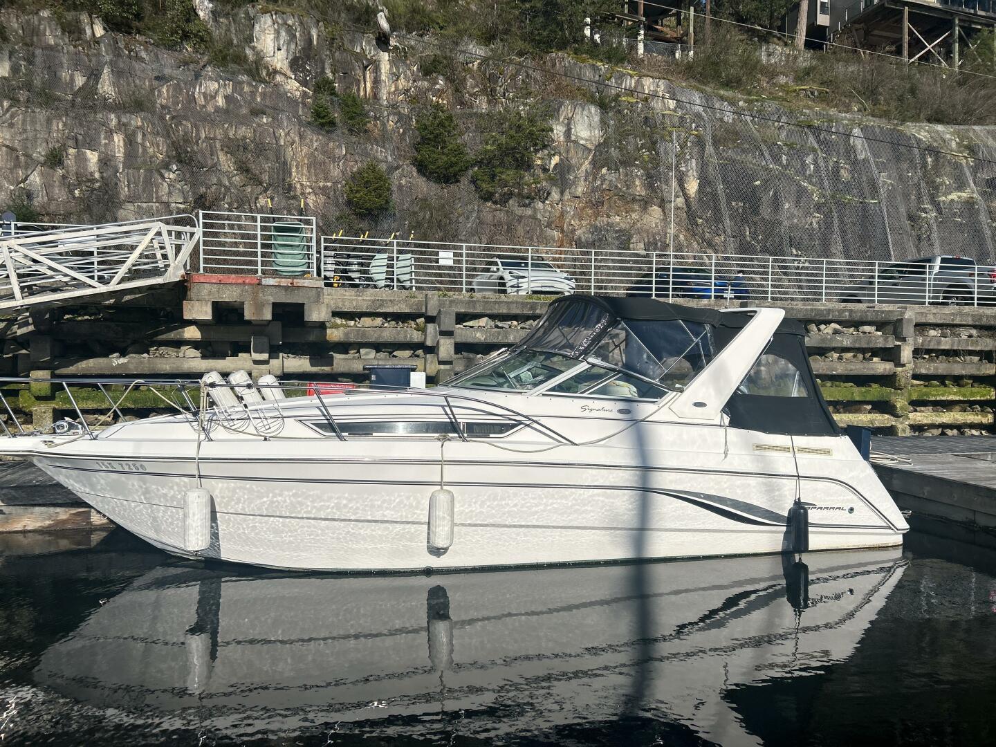 Chaparral Signature 290 Chaparral Signature 290 boat, 2000 model, docked by rocky shoreline.