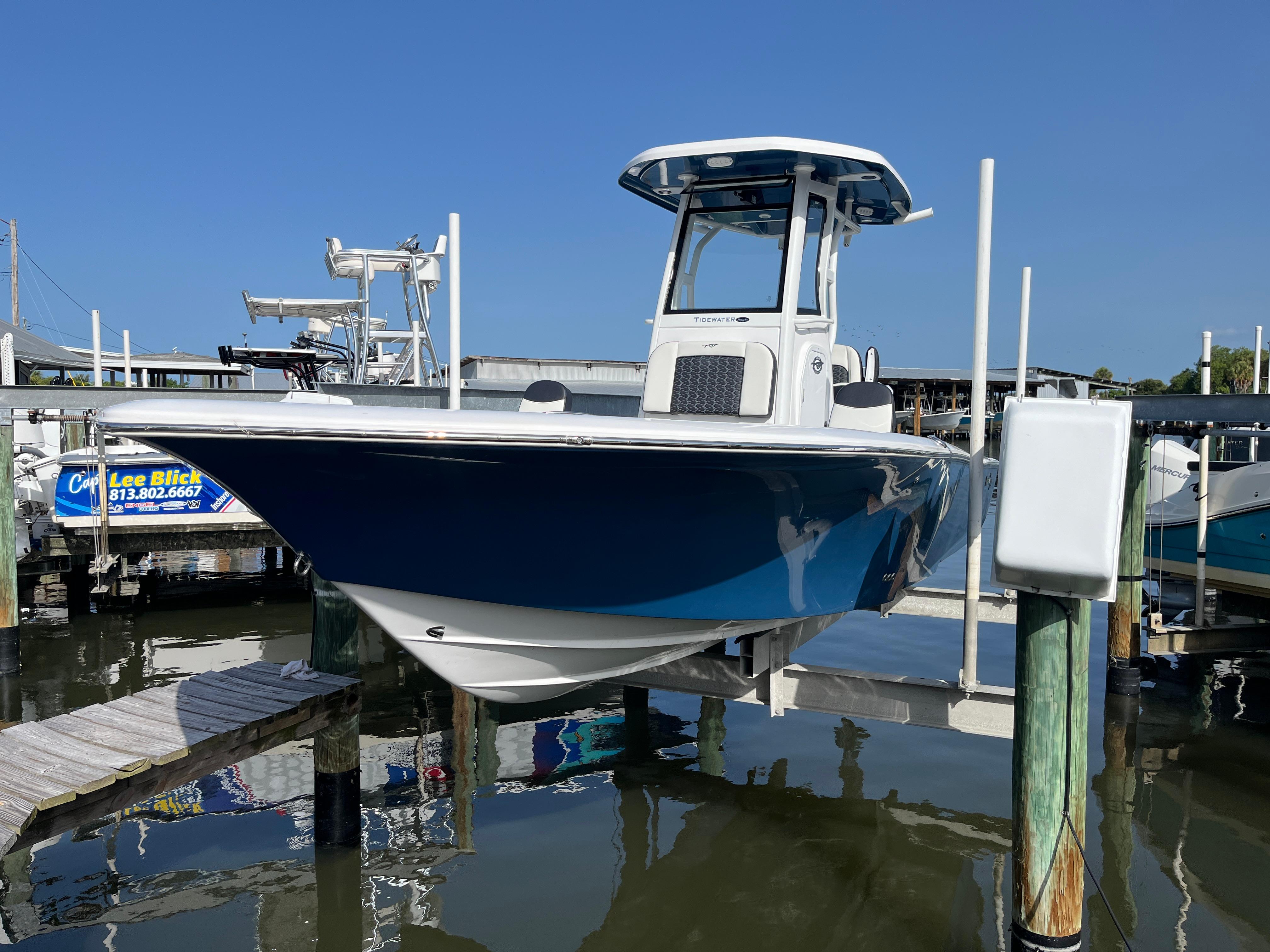 Tidewater 2500 Carolina Bay 2024 Tidewater 2500 Carolina Bay boat docked at marina, blue hull, clear sky background.