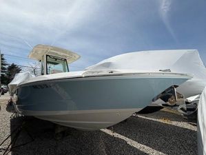 Boston Whaler 280 Dauntless 2023 Boston Whaler 280 Dauntless boat on gravel, partially covered, under a clear blue sky.