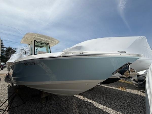 Boston Whaler 280 Dauntless 2023 Boston Whaler 280 Dauntless boat on gravel, partially covered, under a clear blue sky.