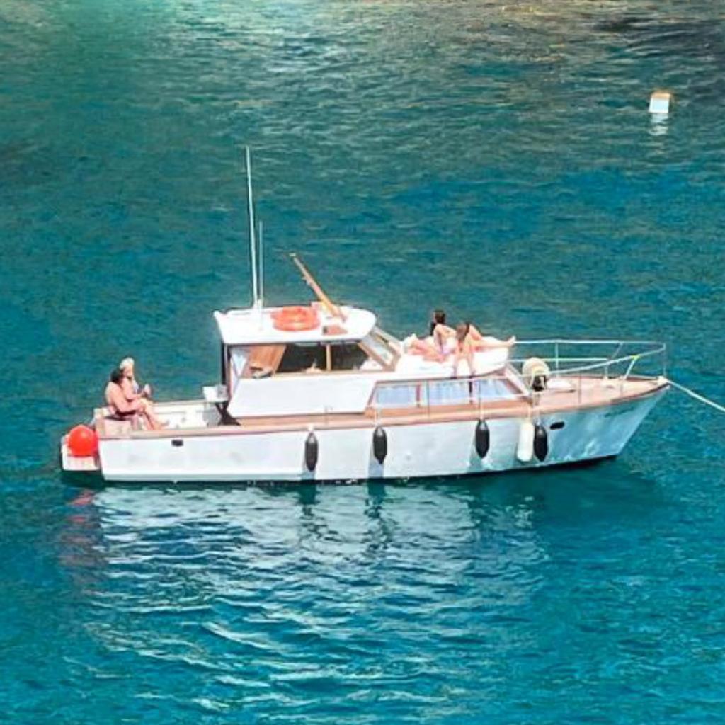 Chris-Craft astilleros UDONDO 1965 Chris-Craft Astilleros UDONDO boat on clear blue water with people relaxing.