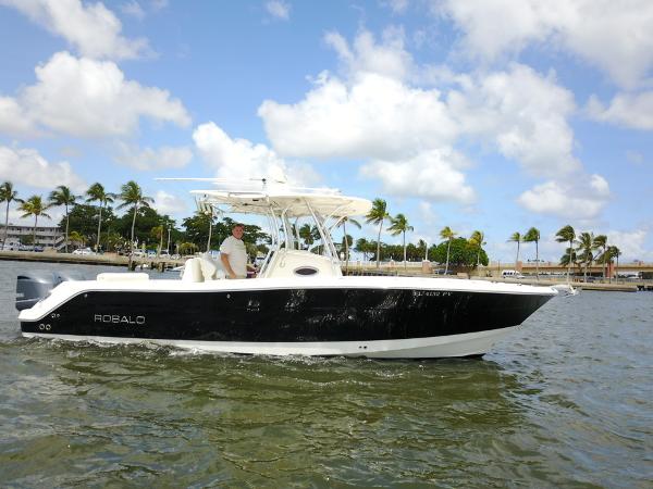 Robalo R300 Center Console 2015 Robalo R300 Center Console boat cruising on water with palm trees in the background.