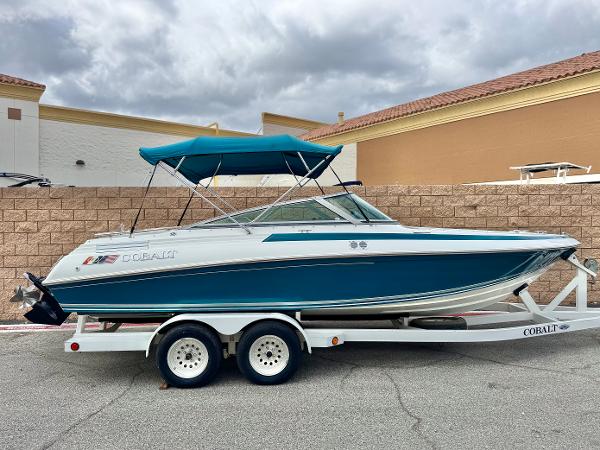 Cobalt 222 1994 Cobalt 222 boat on trailer with blue canopy, parked outdoors.