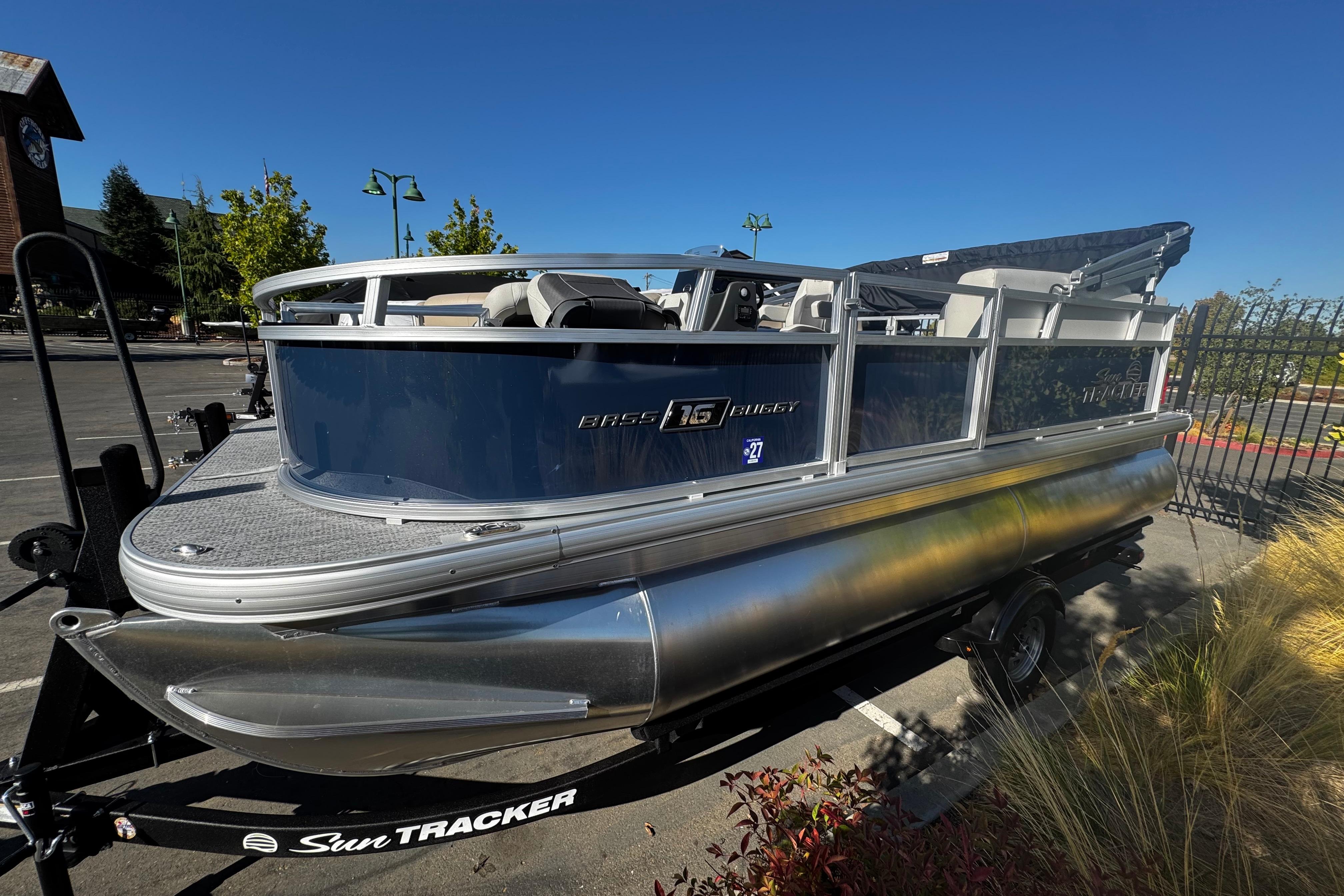 Sun Tracker Bass Buggy 16 XL Select 2026 Sun Tracker Bass Buggy 16 XL Select pontoon boat in parking lot.