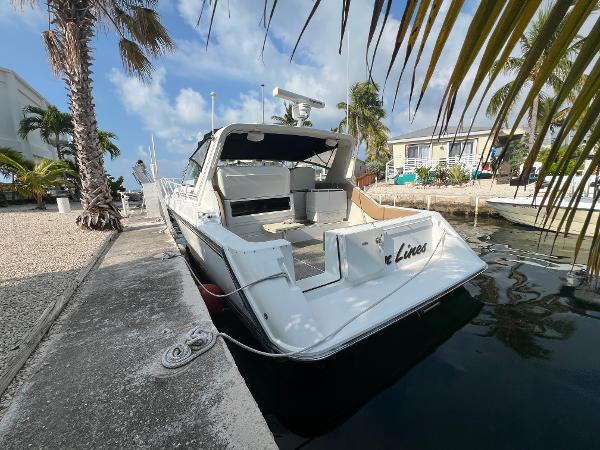 Trojan 11 Meter Express 1990 Trojan 11 Meter Express boat docked by palm trees and waterfront homes.