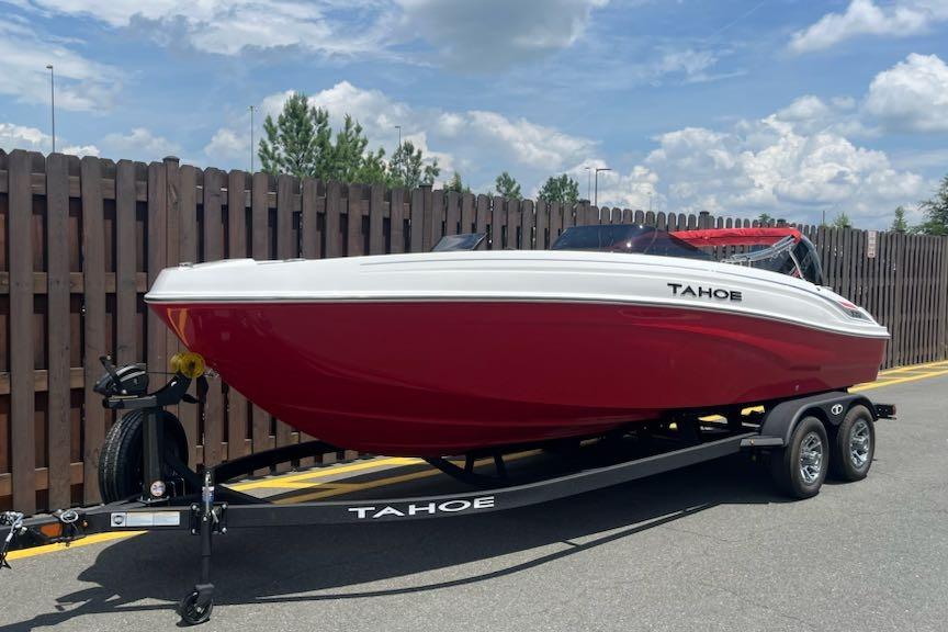 Tahoe T21 2025 Tahoe T21 boat in red on trailer, parked outdoors under blue sky.