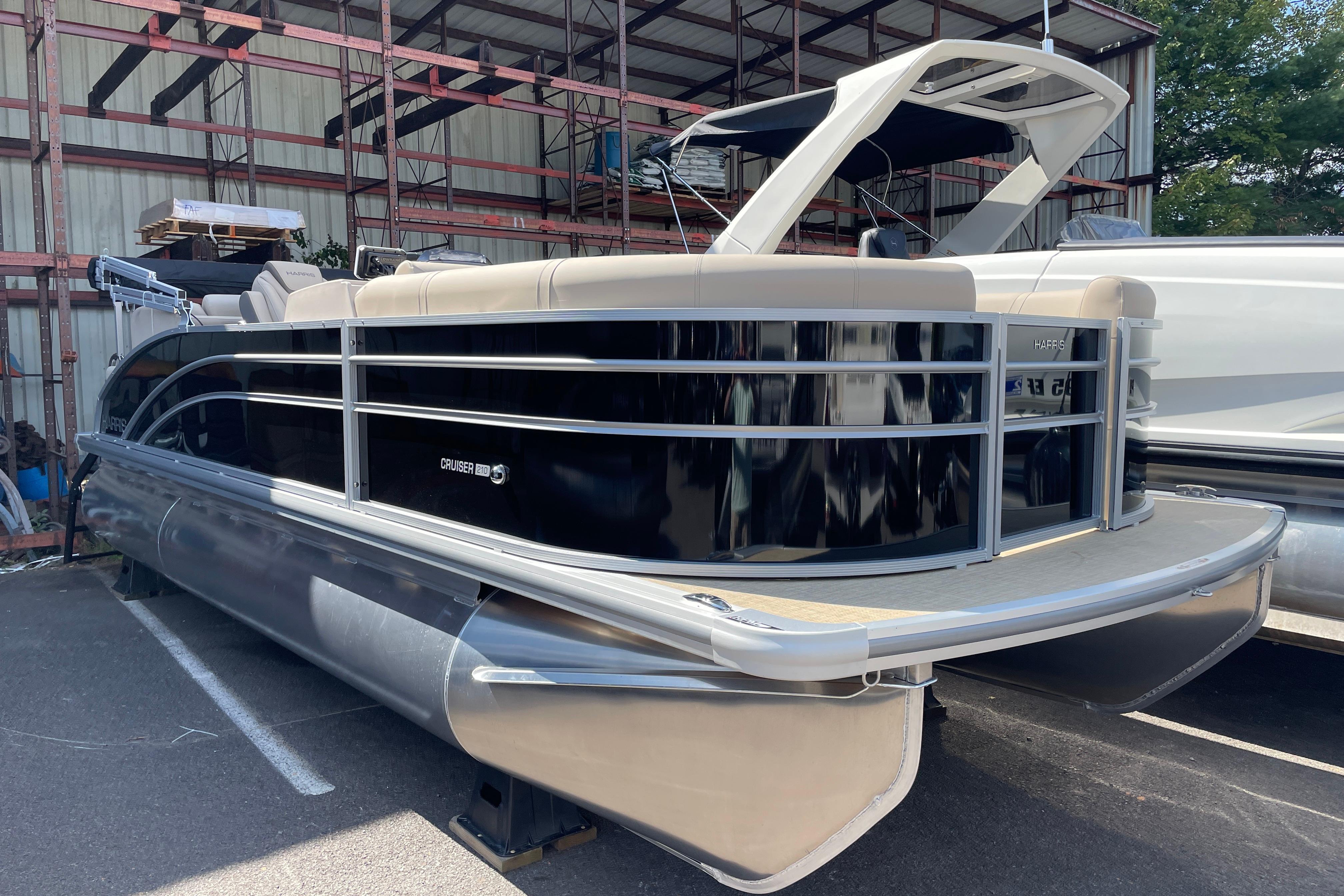 Harris Cruiser 210 CW 2026 Harris Cruiser 210 CW pontoon boat in storage, featuring sleek design and modern amenities.