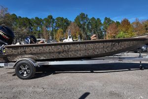 Xpress X18DB 2026 Xpress X18DB boat with camouflage design on a trailer, parked outdoors.