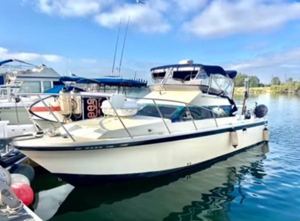 Skipjack 28 Flybridge 1990 Skipjack 28 Flybridge boat docked in a marina under a clear blue sky.