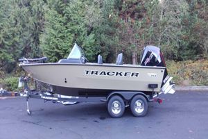 Tracker Targa V-19 Combo 2026 Tracker Targa V-19 Combo boat on trailer, parked near lush green trees.