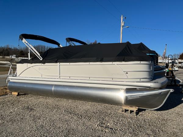 Sweetwater 2286SB 2024 Sweetwater 2286SB pontoon boat with black canopy on gravel lot.