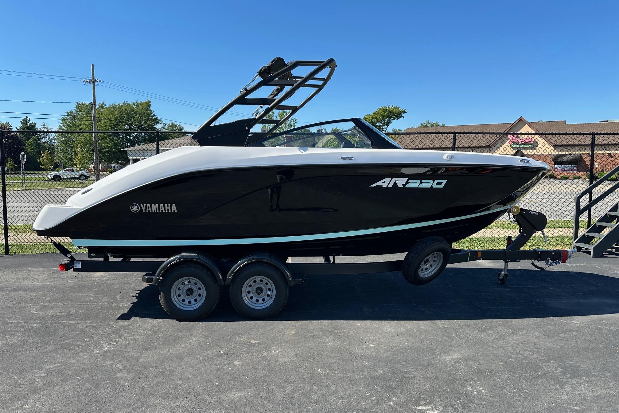 Yamaha Boats AR220 2026 Yamaha Boats AR220 on trailer, sleek black design, parked outdoors.