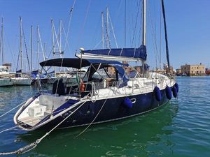 Jeanneau Sun Odyssey 51 1990 Jeanneau Sun Odyssey 51 sailboat docked in a marina, featuring blue hull and canopy.