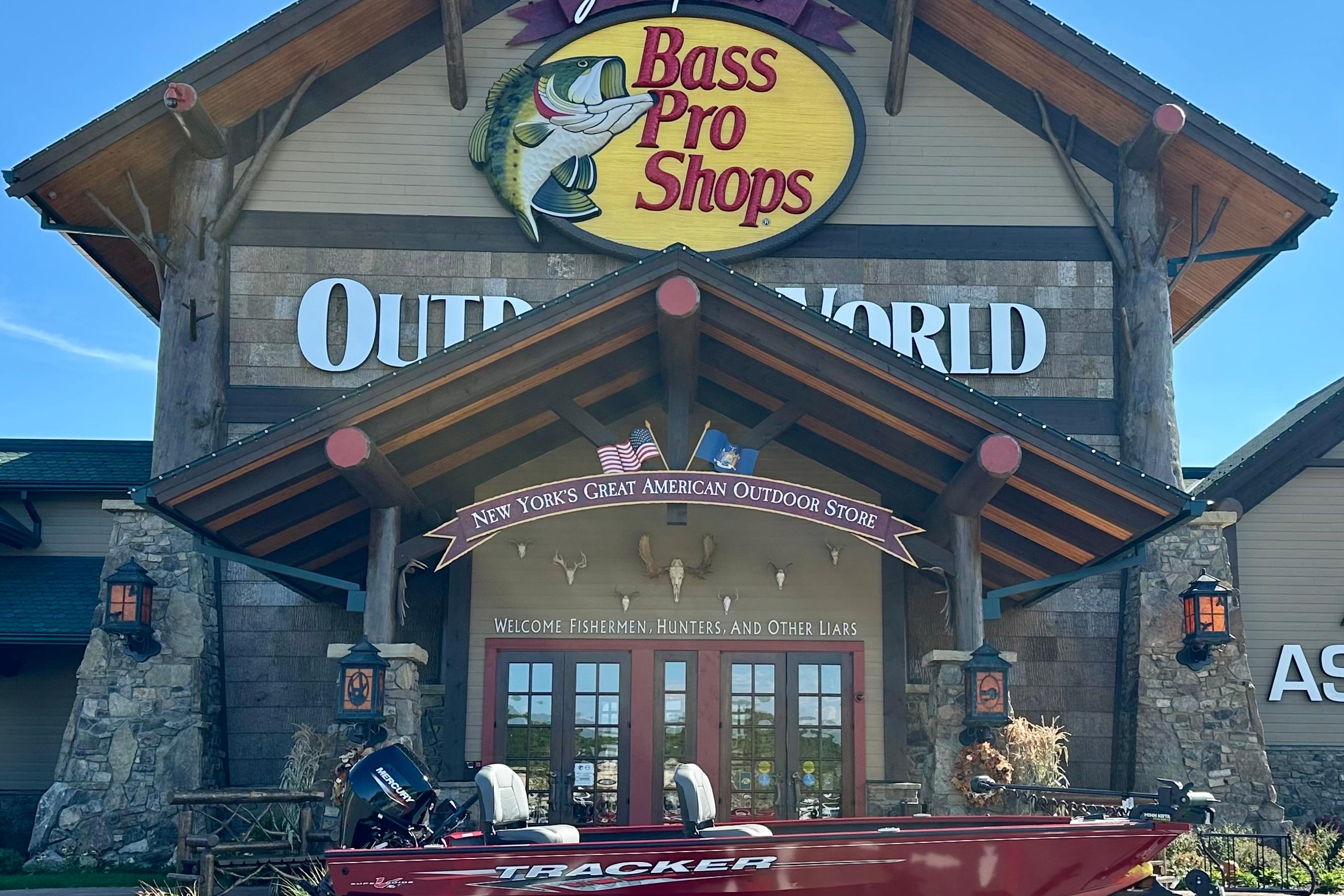 Tracker Super Guide V-16 T Bass Pro Shops entrance with 2025 Tracker Super Guide V-16 T boat displayed outside.