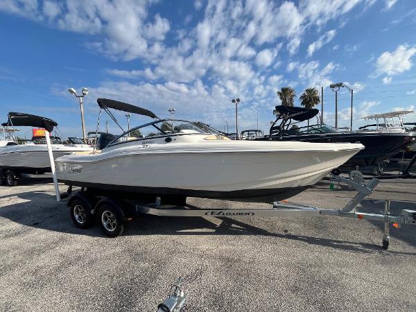 Scout 210 Dorado 2021 Scout 210 Dorado boat on trailer in marina under blue sky.