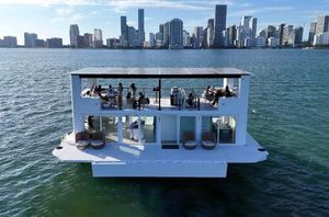 Custom Arkup 50 Floating luxury home, Arkup 50, on water with city skyline in background, 2025 model.