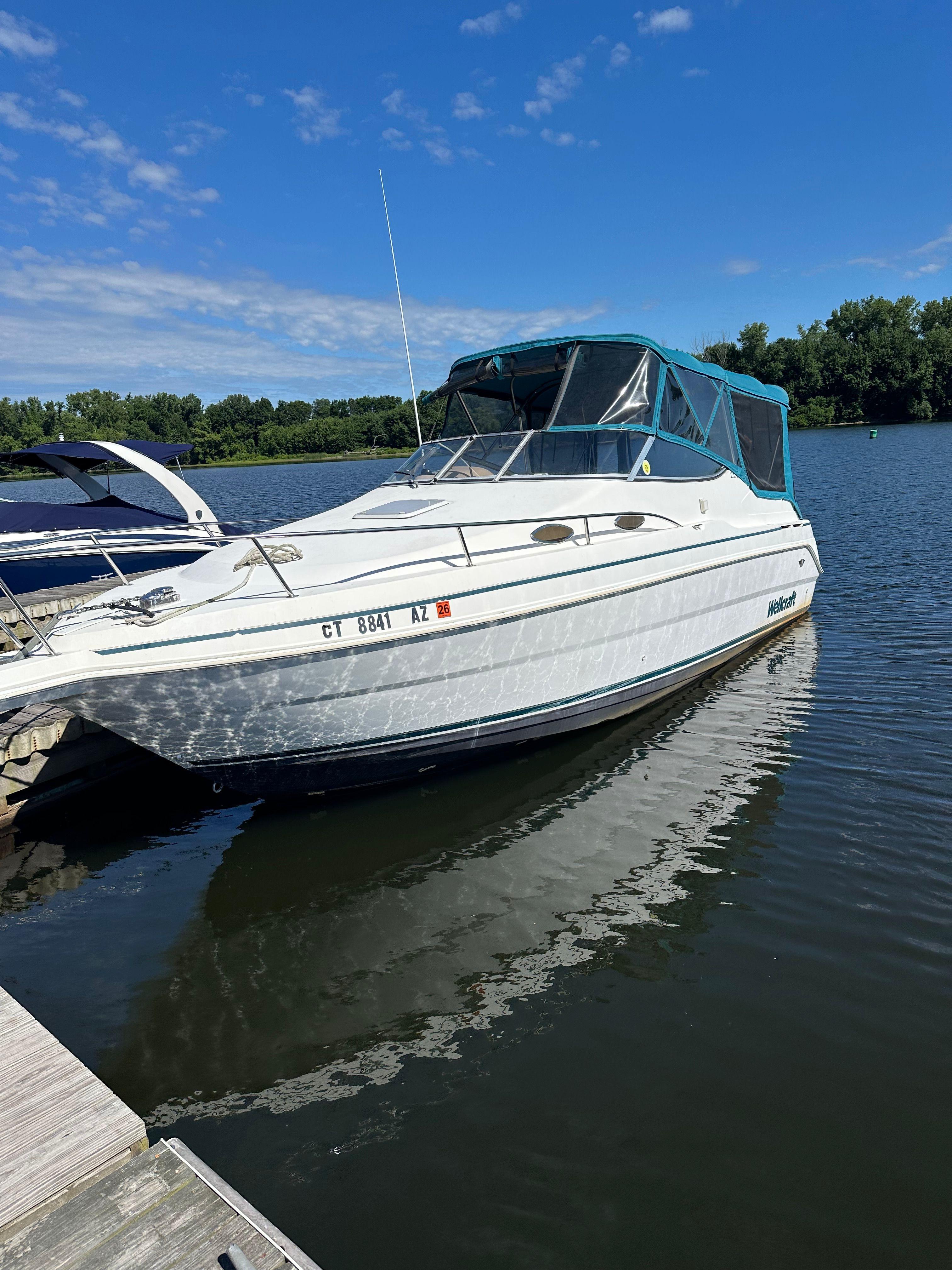 Wellcraft 260 1998 Wellcraft 260 boat docked on a sunny day with clear blue skies.