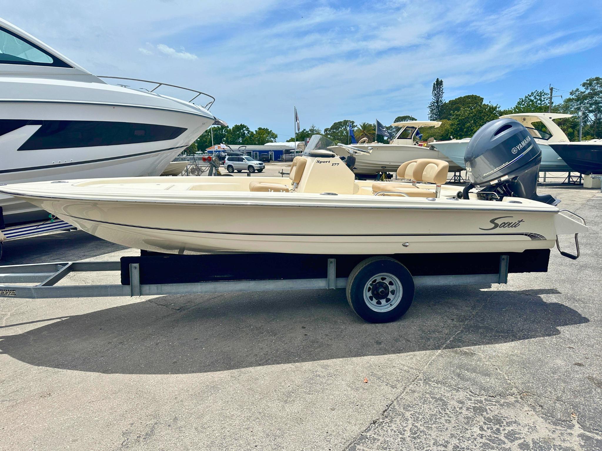 Scout 177 Sport 2025 Scout 177 Sport boat on trailer, parked outdoors, featuring Yamaha outboard motor.