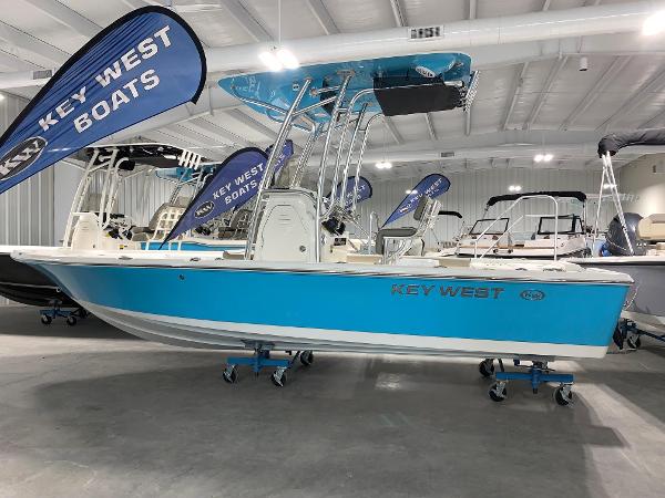 Key West 210 Bay Reef 2024 Key West 210 Bay Reef boat displayed in a showroom with Key West Boats banners.