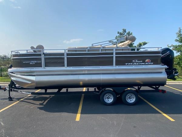 Sun Tracker SportFish 20 DLX 2025 Sun Tracker SportFish 20 DLX pontoon boat on trailer in parking lot.
