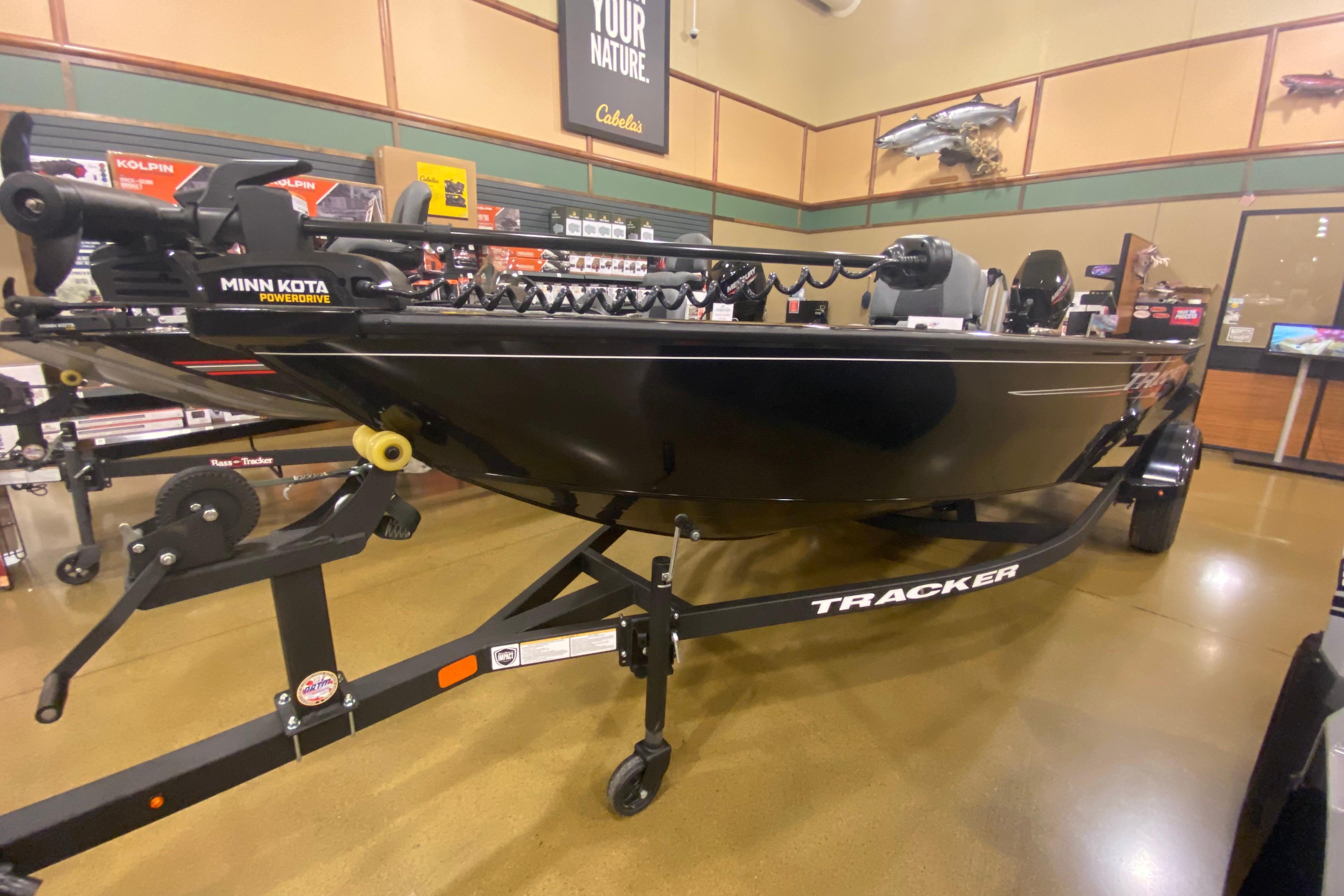 Tracker Super Guide V-16 T 2025 Tracker Super Guide V-16 T boat displayed in a showroom with Minn Kota motor.