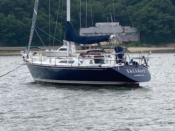 C&C 41 1988 C&C 41 sailboat "Valliant" anchored on calm water near a wooded shoreline.