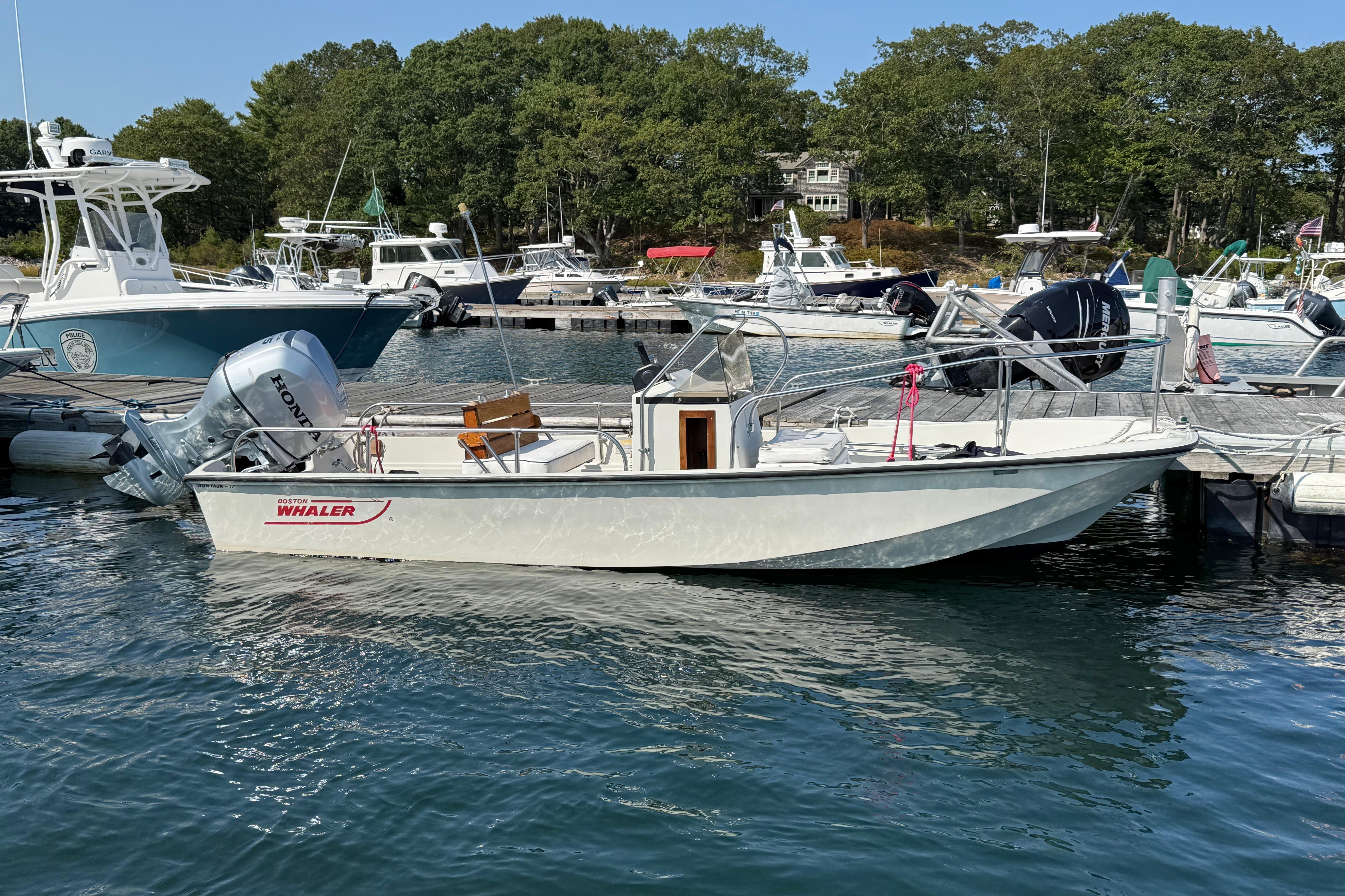 Boston Whaler 170 Montauk 1985 Boston Whaler 170 Montauk boat docked in a marina with other vessels.