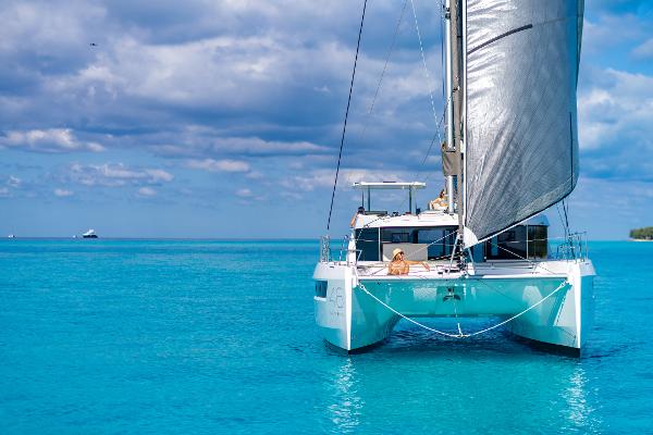 Leopard 46 2025 Leopard 46 catamaran sailing on clear blue ocean under a partly cloudy sky.