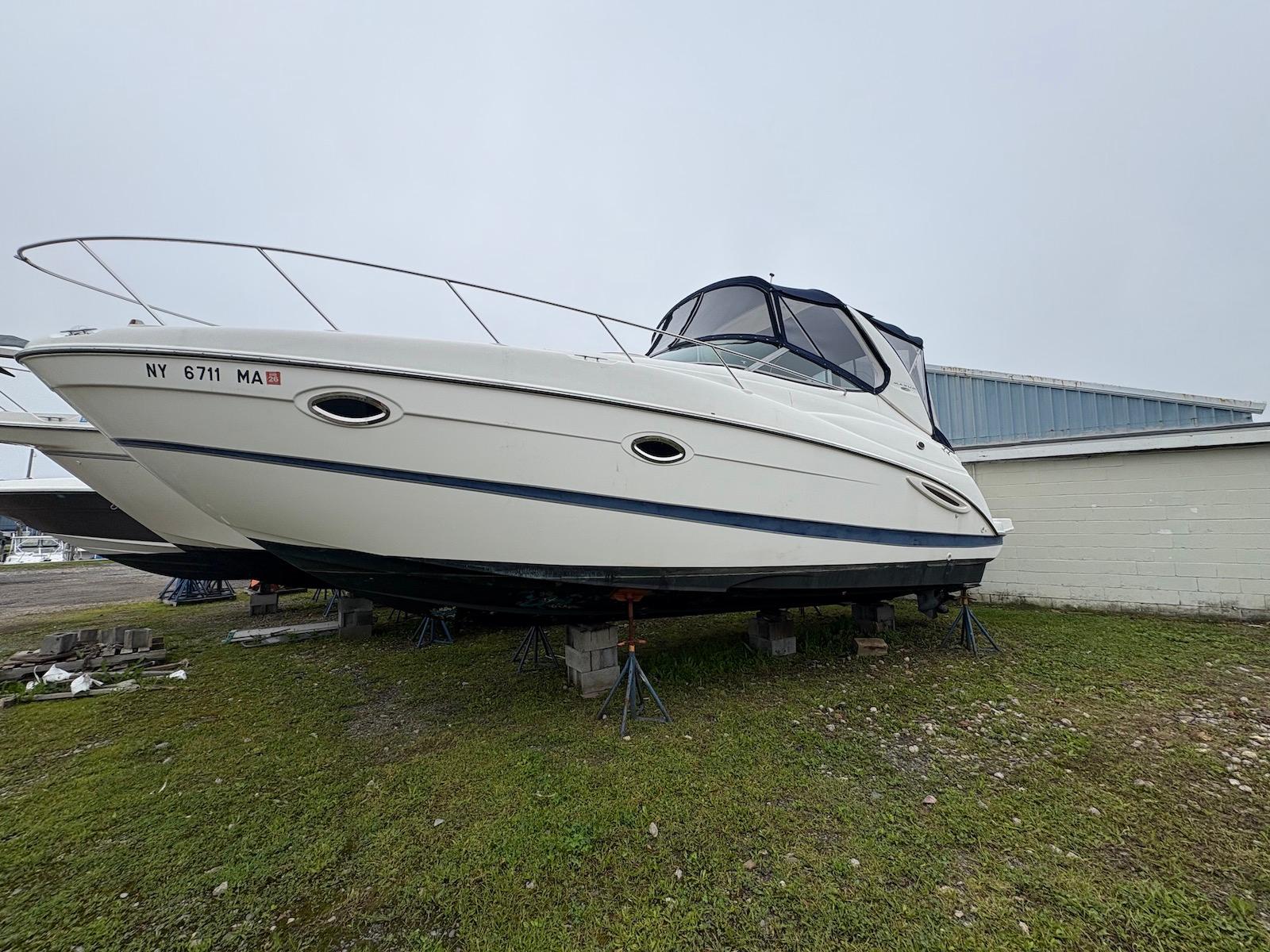 Maxum 3100 SE 2004 Maxum 3100 SE boat on stands, displayed outdoors on grass.