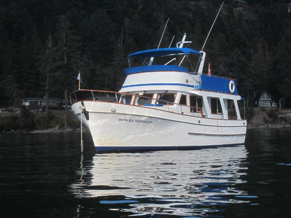 Ocean Alexander Europa 1982 Ocean Alexander Europa yacht on calm water, surrounded by forested shoreline.