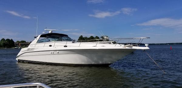 Sea Ray 450 Sundancer 1998 Sea Ray 450 Sundancer yacht anchored on a calm lake under a clear blue sky.