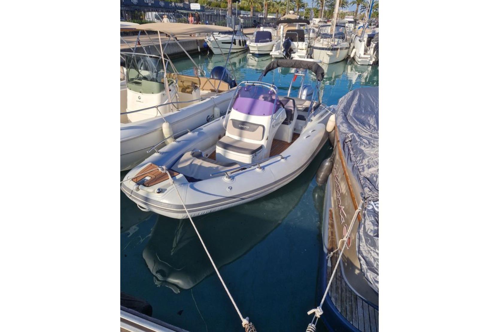 Grand G580 2019 Grand G580 boat docked in a marina, surrounded by other vessels.