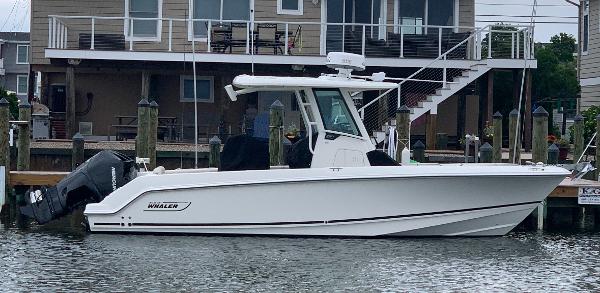 Boston Whaler 250 Outrage 2021 Boston Whaler 250 Outrage boat docked near waterfront house.