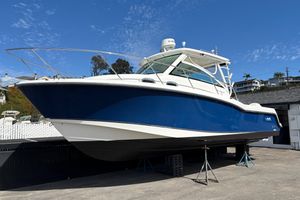 Boston Whaler 315 Conquest 2016 Boston Whaler 315 Conquest boat on stands, blue and white exterior, clear sky background.