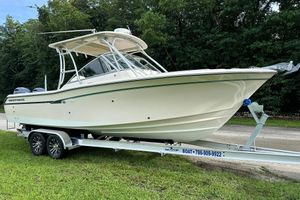 Grady-White Freedom 275 2011 Grady-White Freedom 275 boat on trailer, parked on grass, with lush trees in background.
