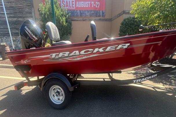 Tracker Super Guide V-16 T 2025 Tracker Super Guide V-16 T boat in red on trailer, outdoor sale event.