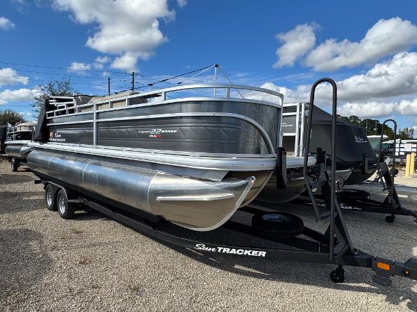 Sun Tracker Fishin' Barge 22 XP3 2025 Sun Tracker Fishin' Barge 22 XP3 pontoon boat on trailer under blue sky.