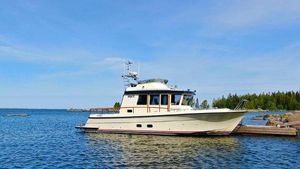 Targa 35 Targa 35 boat from 2016 docked on a serene lake with clear blue skies.