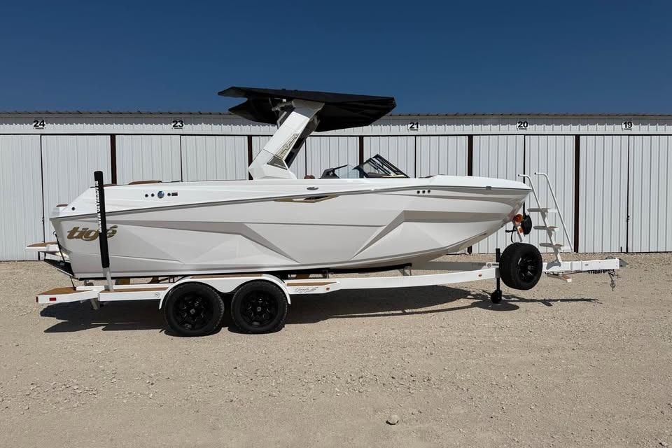 Tigé Z3 2026 Tigé Z3 boat on trailer, parked in front of storage units under clear blue sky.