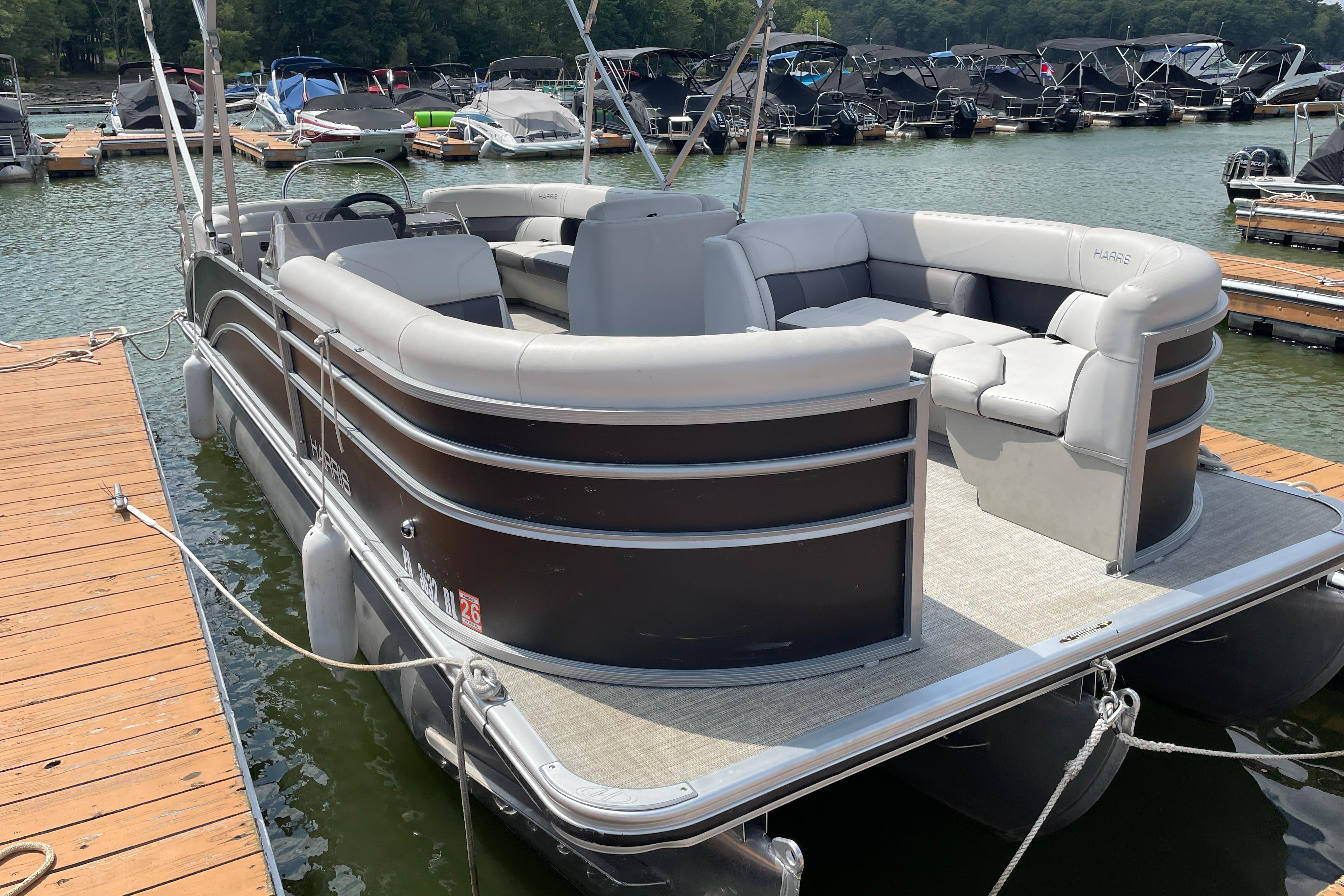 Harris Cruiser 230 CW 2023 Harris Cruiser 230 CW pontoon boat docked at marina.