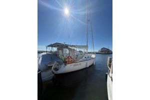 Tartan 3500 Sailboat docked under bright sun, 1998 Tartan 3500 model, marina background.