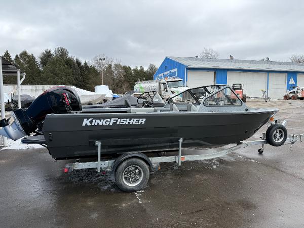 KingFisher 2025 Falcon 2025 KingFisher Falcon boat on trailer, parked outdoors near blue building.