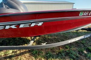 Tracker Pro Team 175 TXW 2024 Tracker Pro Team 175 TXW boat, red exterior, on a trailer, parked on grass.