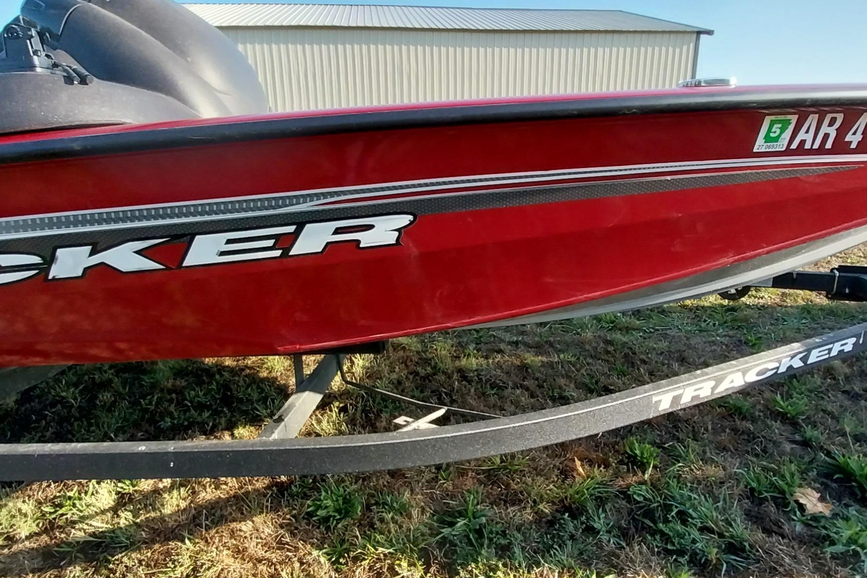 Tracker Pro Team 175 TXW 2024 Tracker Pro Team 175 TXW boat, red exterior, on a trailer, parked on grass.