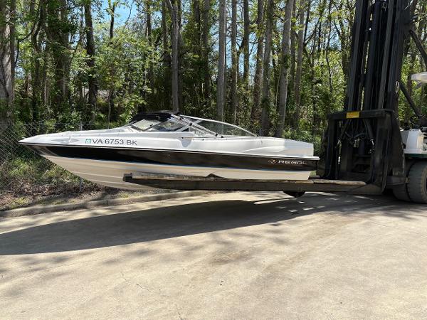 Regal 1800 Bowrider 2005 Regal 1800 Bowrider boat lifted by forklift in wooded area.