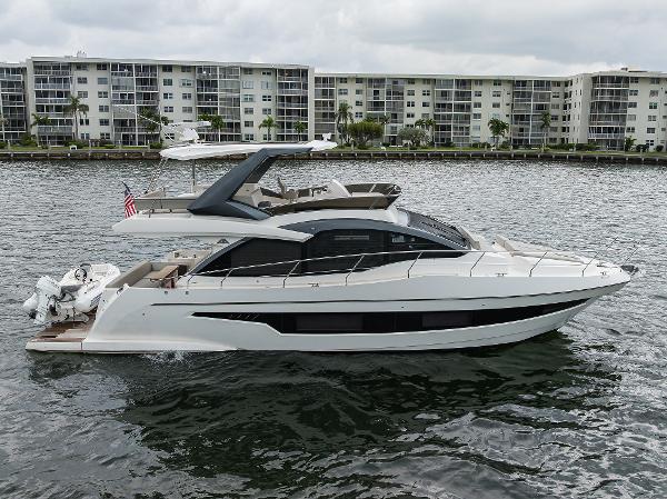 Astondoa 52 2021 Astondoa 52 yacht cruising on water near waterfront apartments.